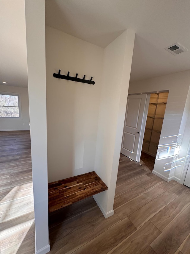 mudroom featuring wood finished floors, baseboards, and visible vents