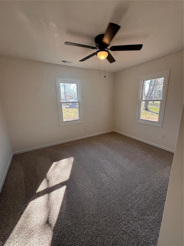unfurnished room featuring visible vents, a wealth of natural light, a ceiling fan, and a textured ceiling