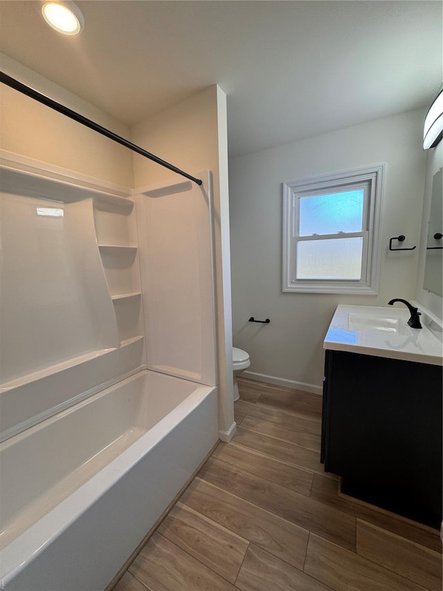 full bathroom with baseboards, toilet, tub / shower combination, vanity, and wood finished floors
