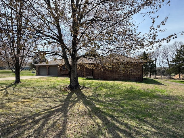 ranch-style house with brick siding, a front lawn, a garage, and concrete driveway