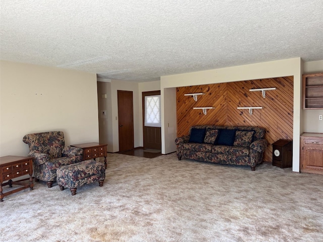 living area featuring a textured ceiling, wooden walls, and carpet floors