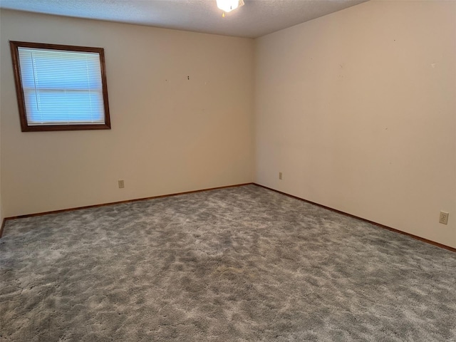 unfurnished room featuring carpet flooring, baseboards, and a textured ceiling