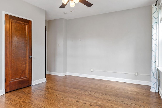 unfurnished room with baseboards, a ceiling fan, and wood finished floors