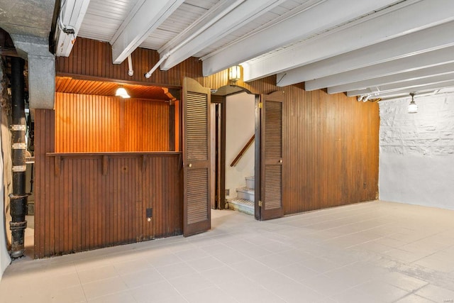 finished below grade area featuring wooden walls and stairway