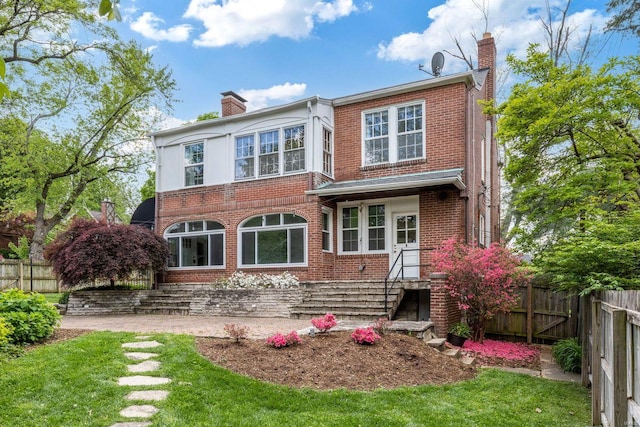 back of property with brick siding, fence, and a chimney