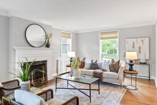 living area with plenty of natural light, crown molding, and wood finished floors