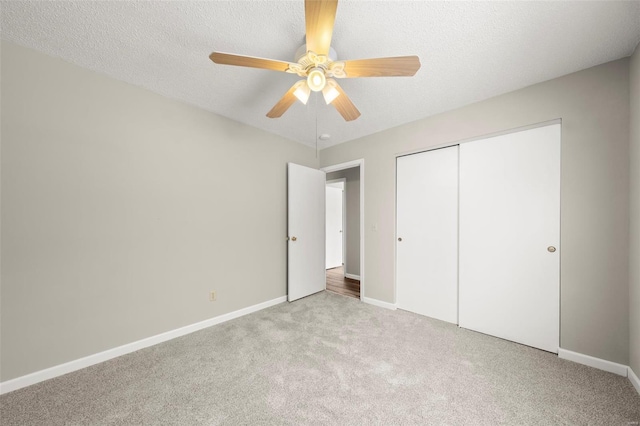 unfurnished bedroom featuring baseboards, ceiling fan, carpet, and a closet