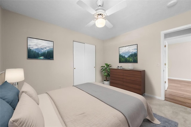 carpeted bedroom with a ceiling fan, baseboards, and a closet
