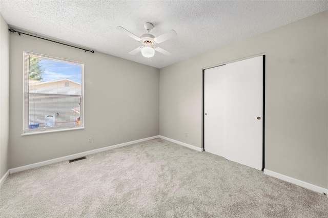 unfurnished bedroom featuring baseboards, carpet, a closet, and a textured ceiling