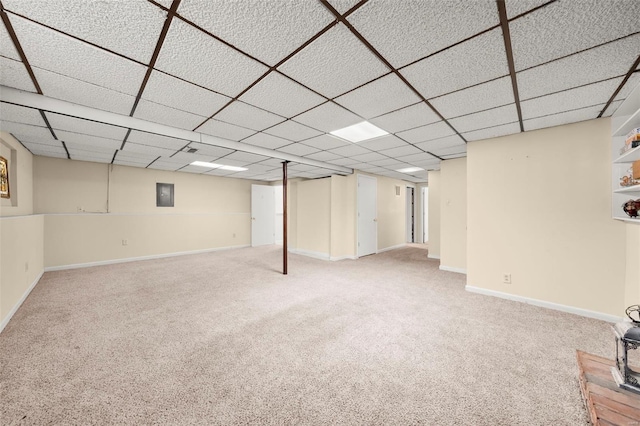 finished basement featuring carpet floors, baseboards, and a drop ceiling