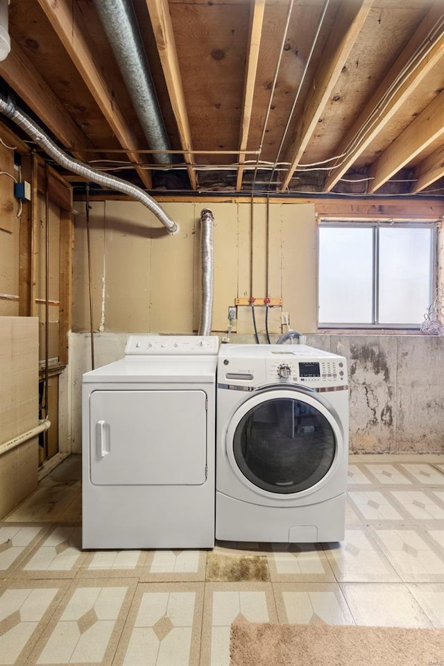 laundry room with laundry area, light floors, and separate washer and dryer