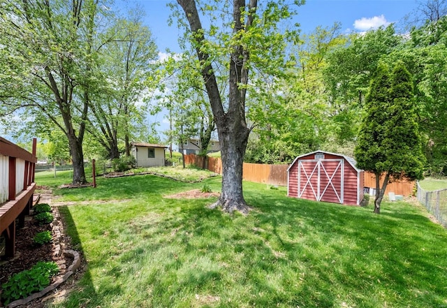 view of yard featuring a fenced backyard, a storage unit, and an outdoor structure