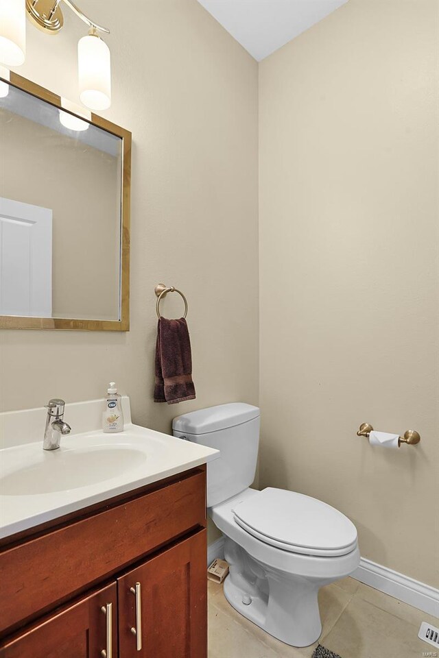 bathroom featuring tile patterned floors, toilet, baseboards, and vanity