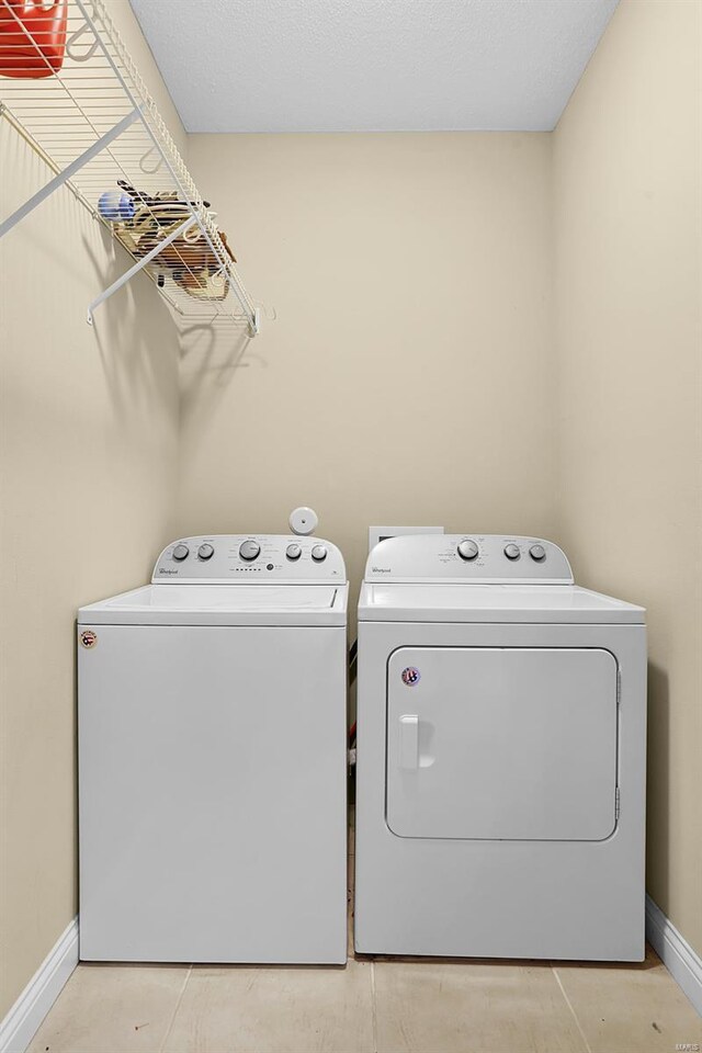 laundry room featuring laundry area, baseboards, and separate washer and dryer