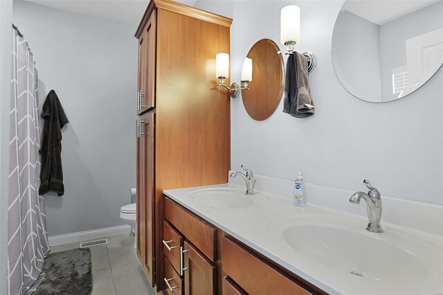 bathroom featuring visible vents, a sink, toilet, and tile patterned flooring