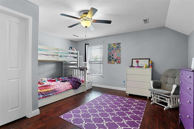 bedroom with a textured ceiling, visible vents, lofted ceiling, and hardwood / wood-style floors