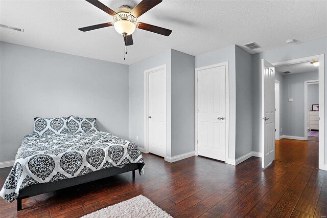 bedroom with hardwood / wood-style flooring, baseboards, ceiling fan, and visible vents