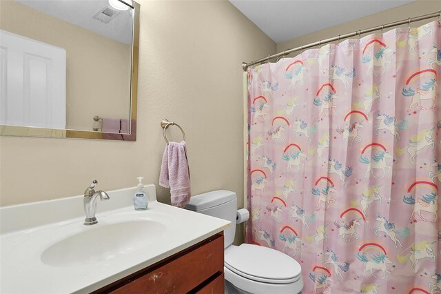 full bath featuring toilet, vanity, and a shower with curtain