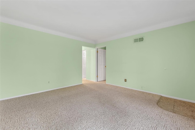 empty room with visible vents, light colored carpet, and baseboards