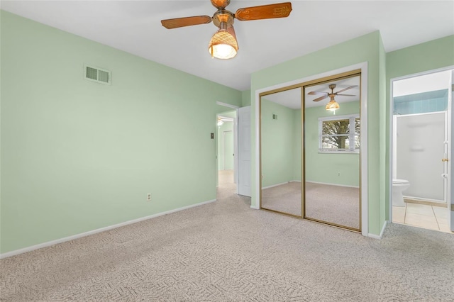 unfurnished bedroom featuring a closet, ensuite bath, visible vents, carpet flooring, and baseboards