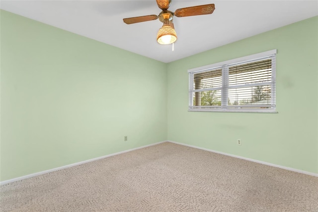 carpeted empty room featuring baseboards and a ceiling fan