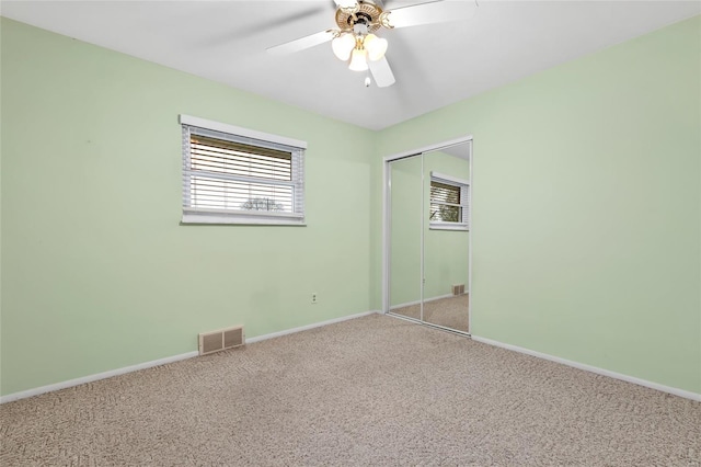 unfurnished bedroom with a closet, carpet flooring, baseboards, and visible vents