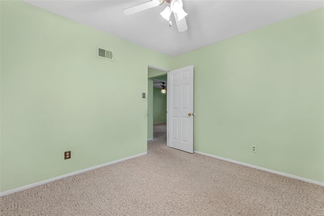 unfurnished room with visible vents, baseboards, a ceiling fan, and light carpet