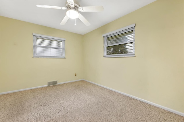 empty room with visible vents, baseboards, a ceiling fan, and carpet