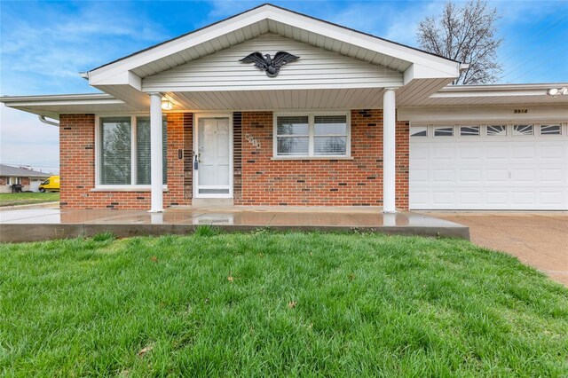 view of front of house featuring driveway, a garage, a front lawn, and brick siding