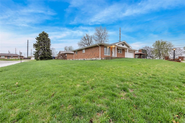 view of home's exterior with an attached garage, brick siding, and a lawn