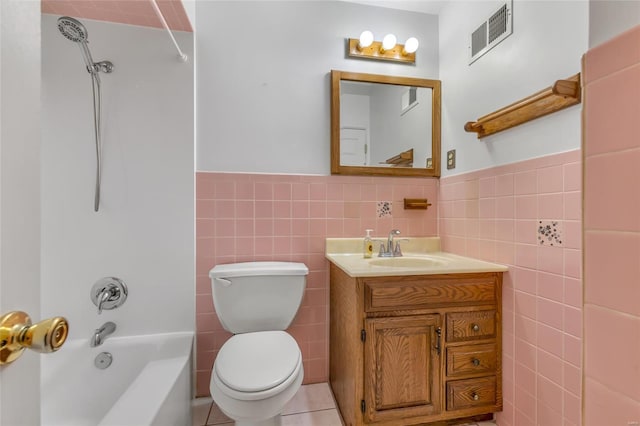 bathroom with visible vents, toilet, tile walls, and  shower combination