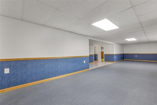 spare room featuring a wainscoted wall and a drop ceiling