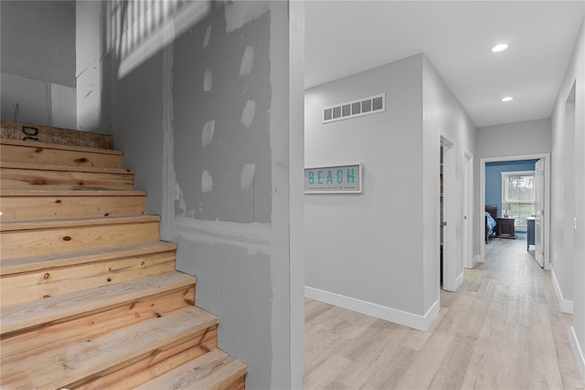 stairs featuring baseboards, wood finished floors, visible vents, and recessed lighting
