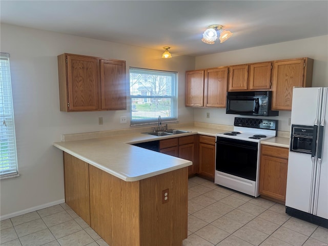 kitchen featuring a peninsula, a sink, black microwave, range with electric stovetop, and white refrigerator with ice dispenser