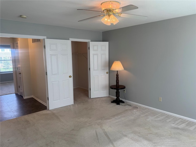 unfurnished bedroom featuring baseboards, carpet flooring, and a spacious closet