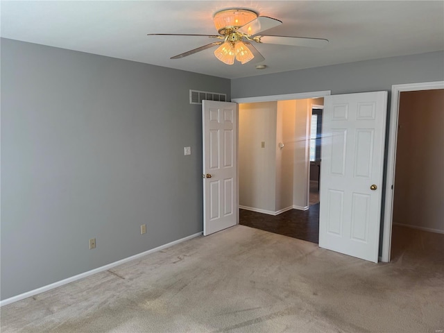 unfurnished bedroom with carpet flooring, baseboards, ceiling fan, and visible vents