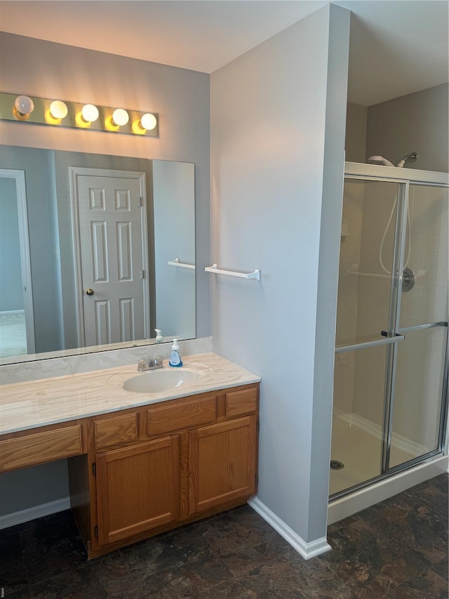 bathroom with vanity, baseboards, and a shower stall