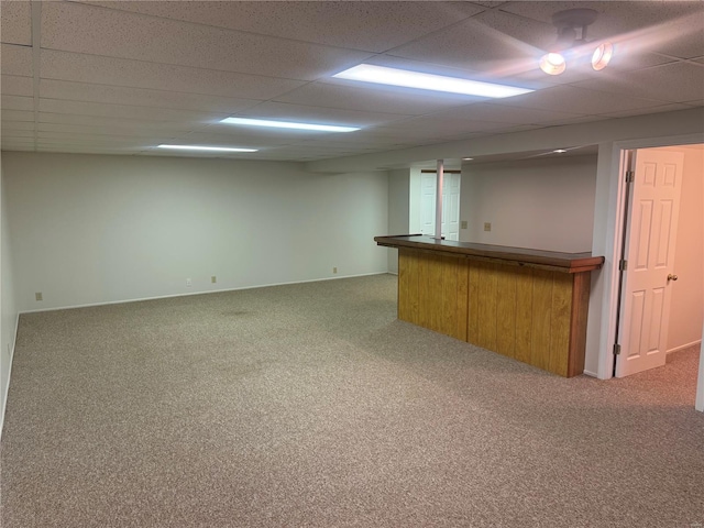 interior space featuring carpet flooring, bar area, and a drop ceiling