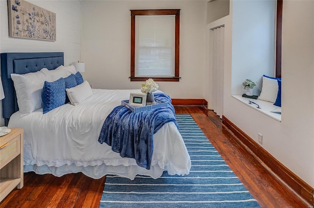 bedroom with baseboards and wood finished floors