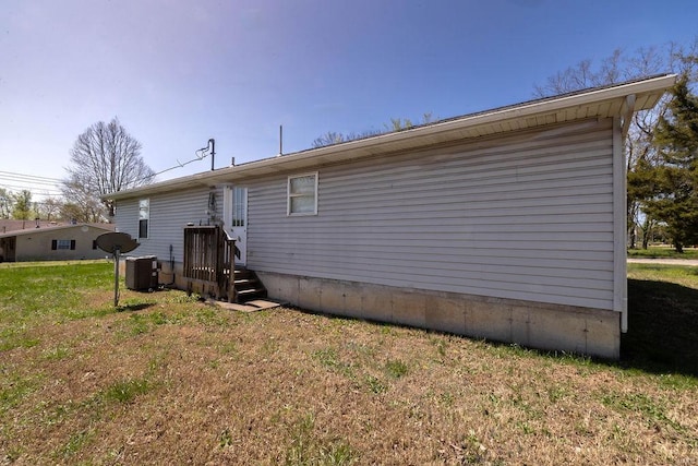 back of property featuring a yard and central AC