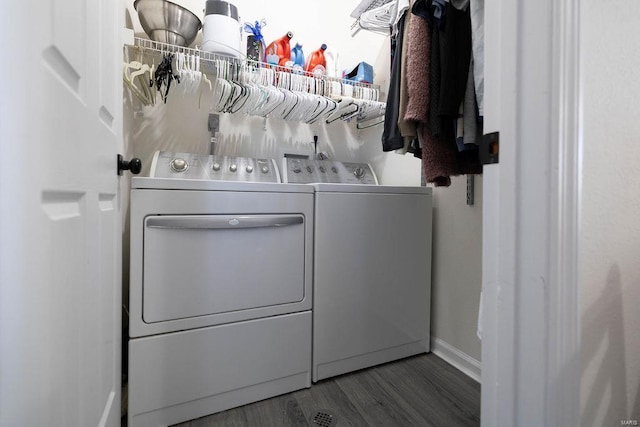 laundry area with laundry area, wood finished floors, baseboards, and washing machine and dryer