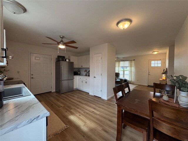 dining room featuring baseboards, wood finished floors, and a ceiling fan