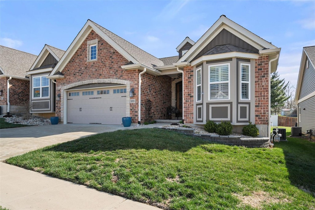 view of front of house featuring concrete driveway, central AC unit, a front lawn, brick siding, and a garage