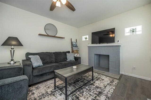 living room featuring baseboards, a brick fireplace, ceiling fan, lofted ceiling, and wood finished floors