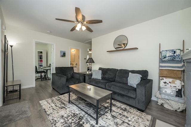 living room featuring baseboards, a ceiling fan, and wood finished floors