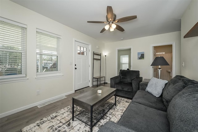 living room with wood finished floors, baseboards, a ceiling fan, and visible vents