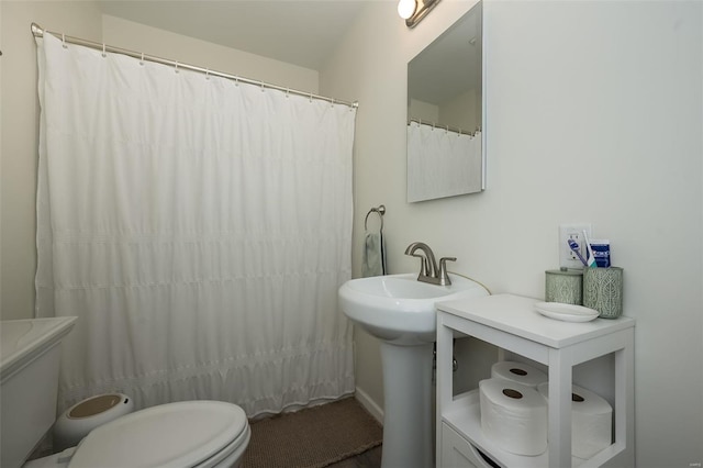 bathroom with curtained shower and toilet