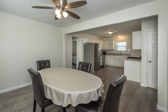 dining room with dark wood-type flooring, baseboards, and ceiling fan
