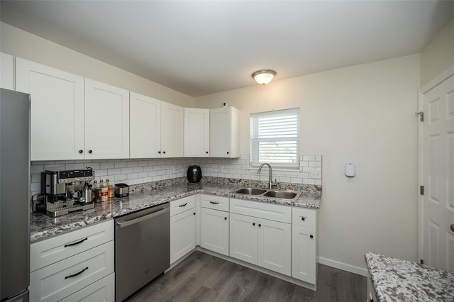 kitchen with freestanding refrigerator, white cabinets, dishwasher, a sink, and backsplash