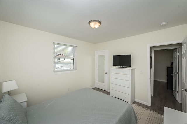 bedroom featuring wood finished floors and baseboards